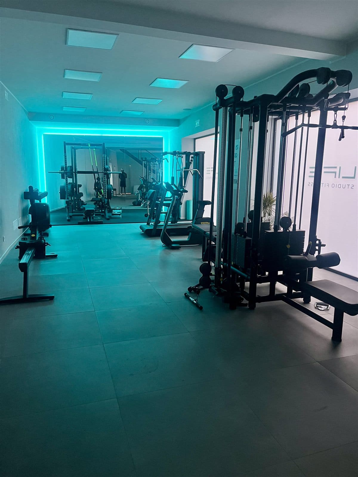 Sala pesi LIFE Studio Fitness con luci ambientali